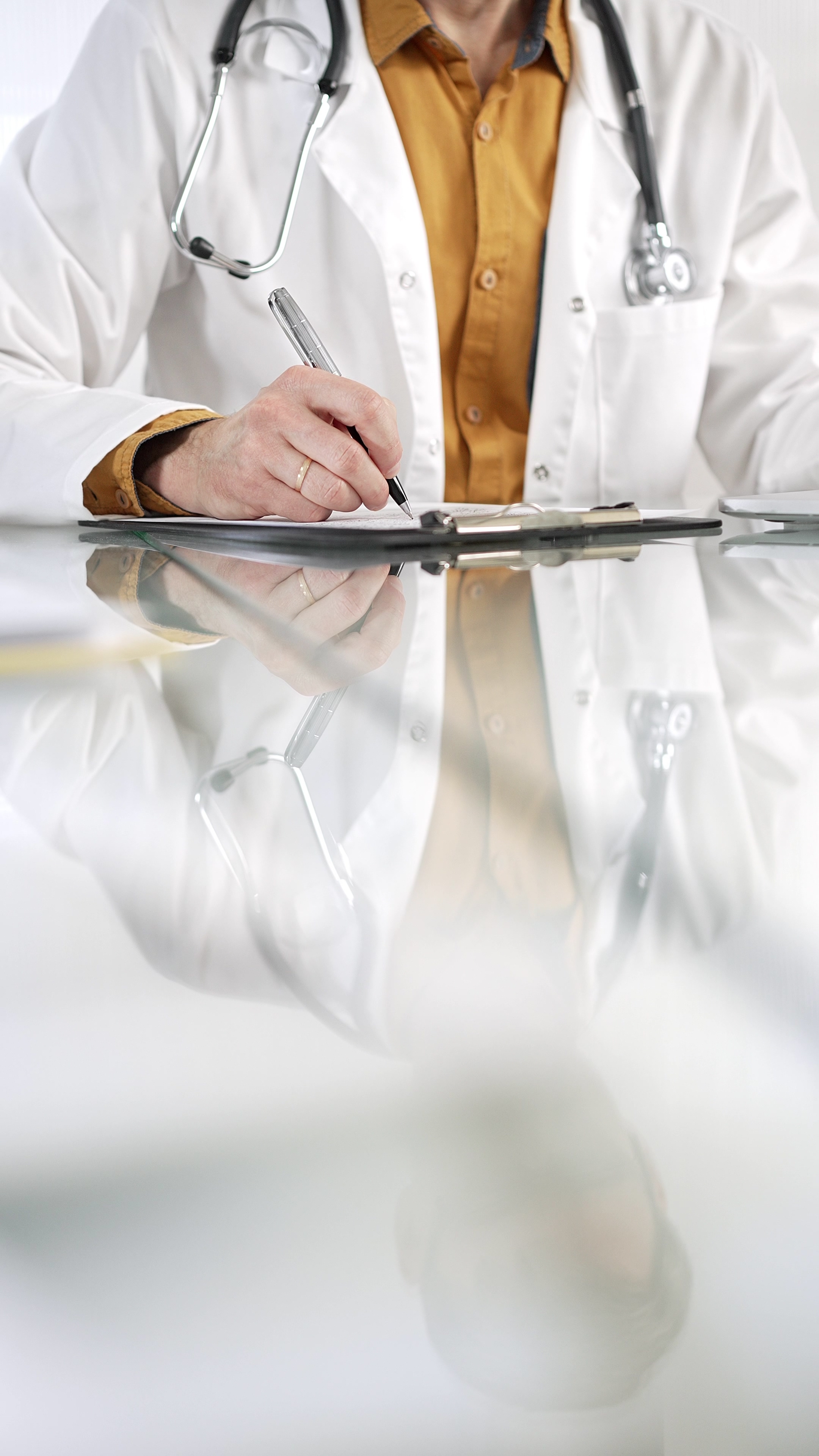 Doctor writing on a file